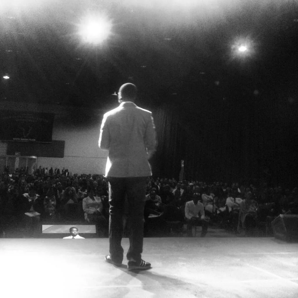 Tony A. Gaskins, Jr. on stage in front of a packed auditorium